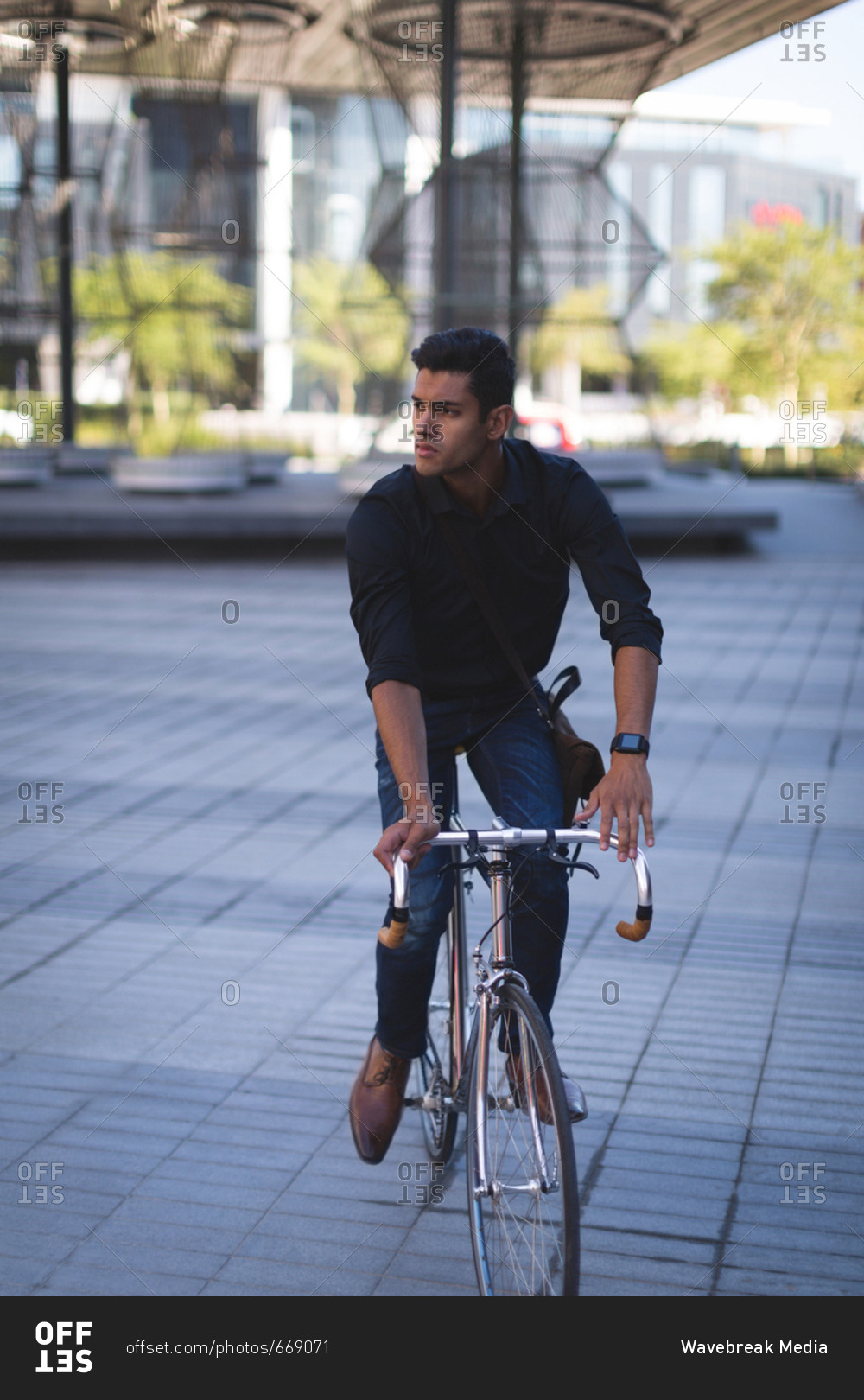 Young businessman riding a bicycle in office premises
