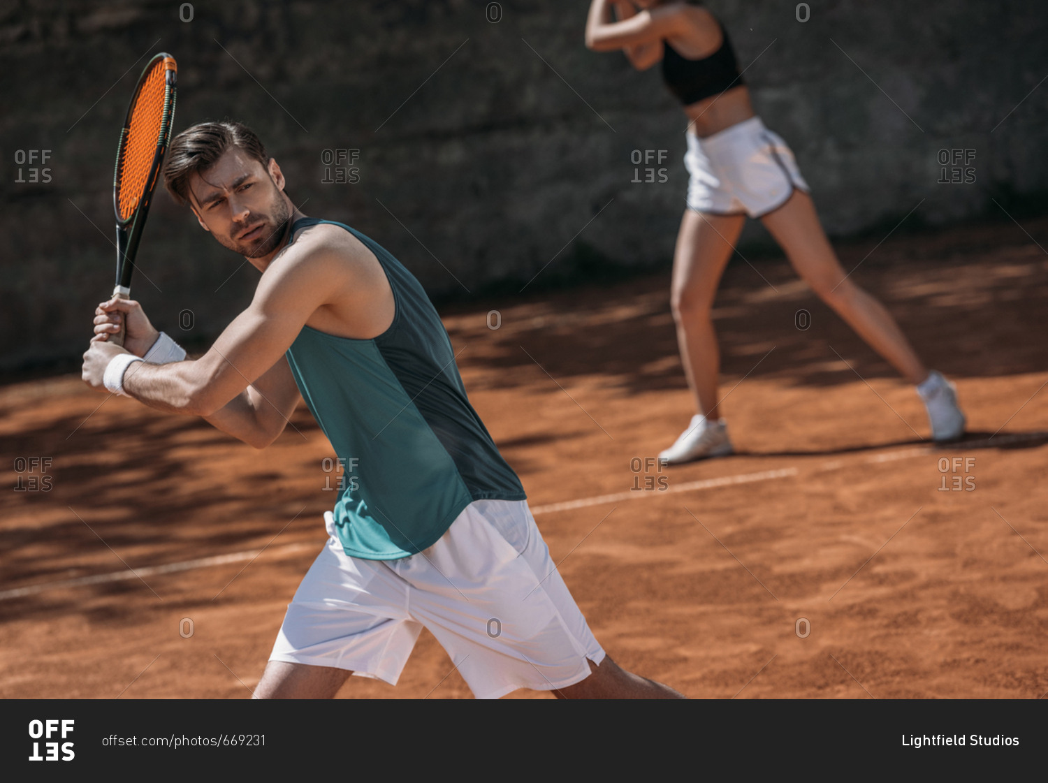 Young athletic couple playing tennis as team