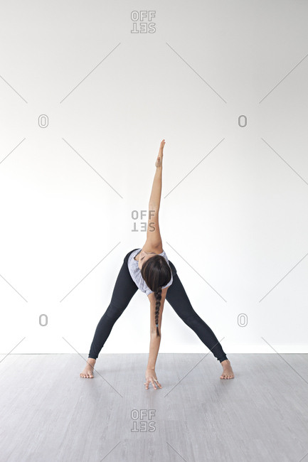 Young woman in wide legged forward bend pose during yoga session in studio