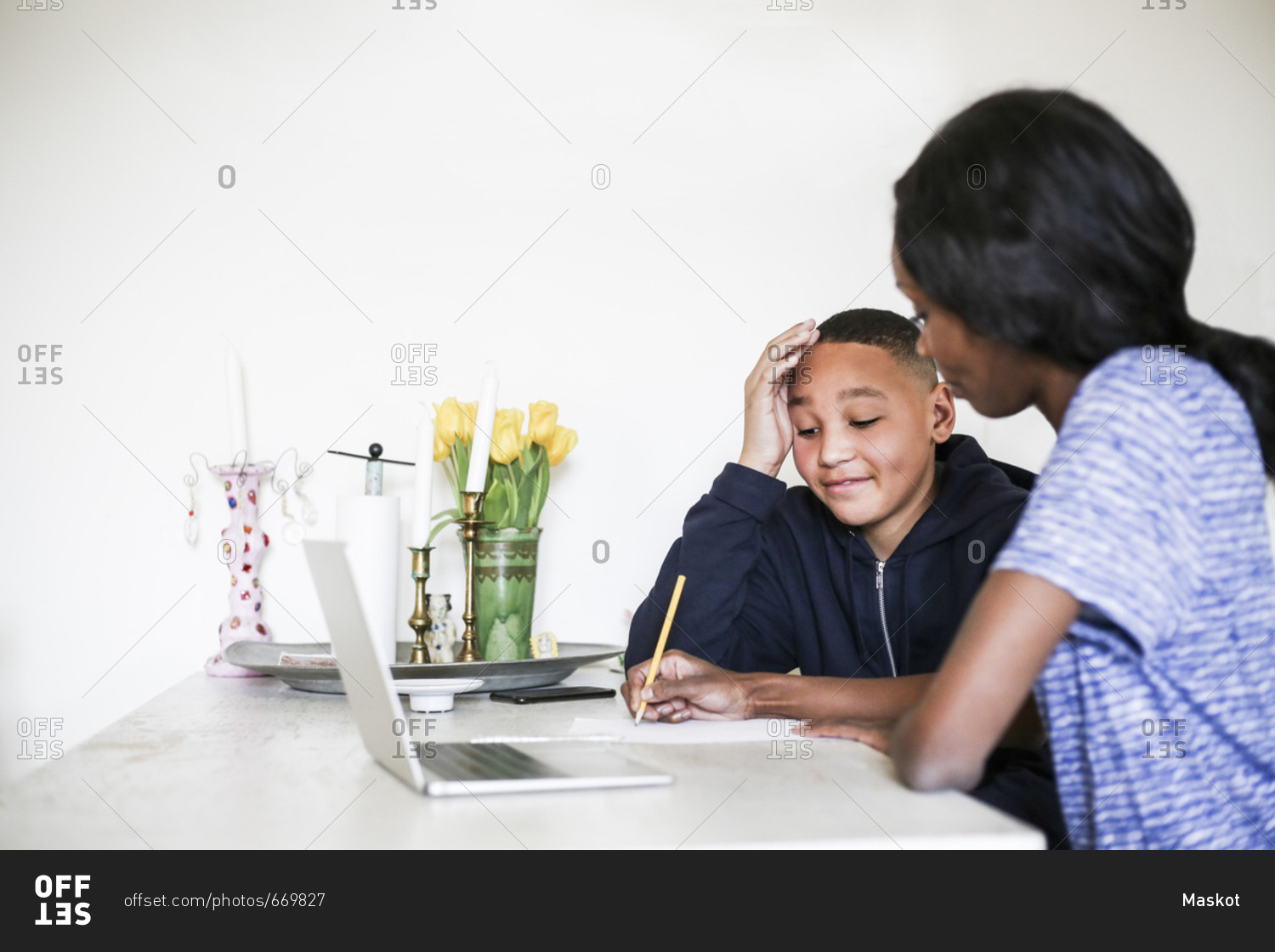 Mother helping son. Ron and Michael ___ at the Table and doing their homework.. Does your son