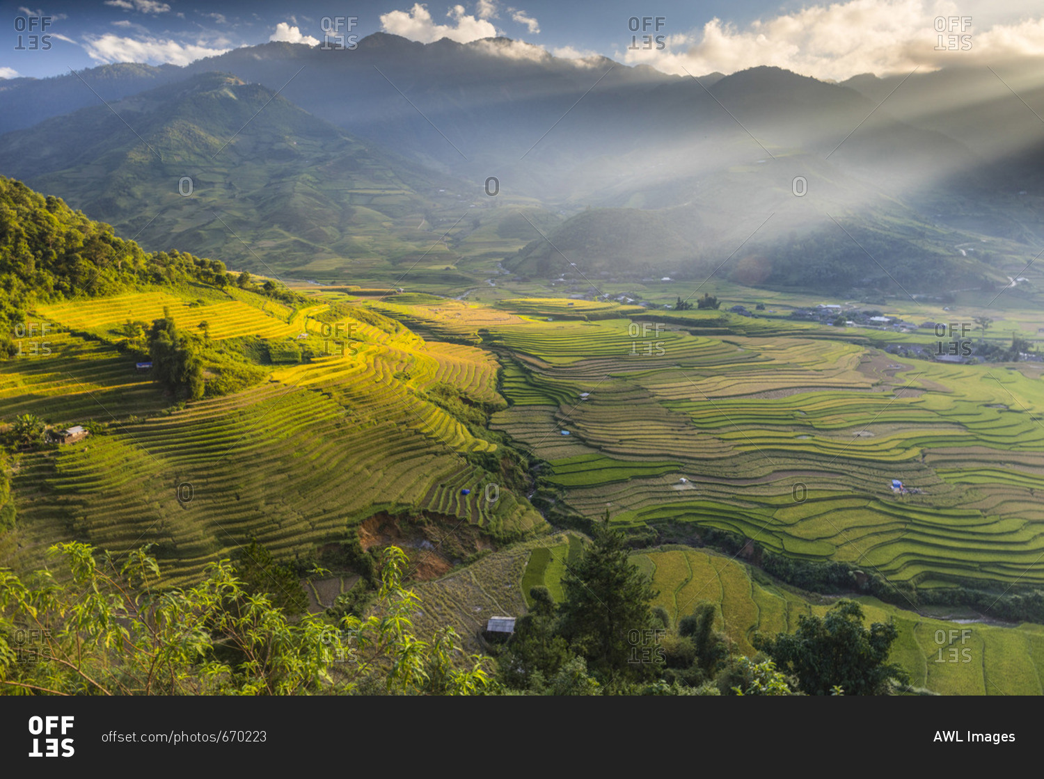 Sun beams over the mountains surrounding the rice terraces at Tu Le ...