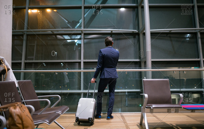 Rear view of businessman waiting at waiting area at airport