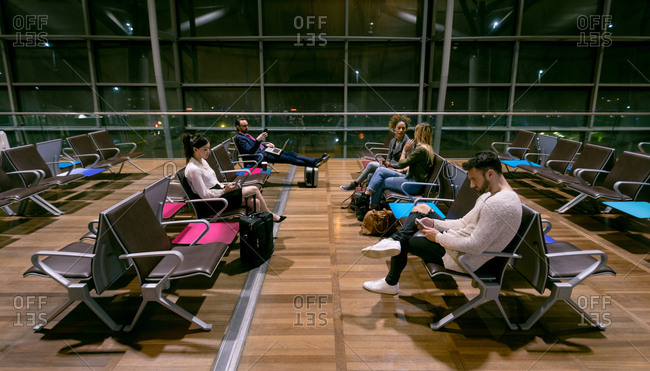 Commuters waiting in waiting area at airport