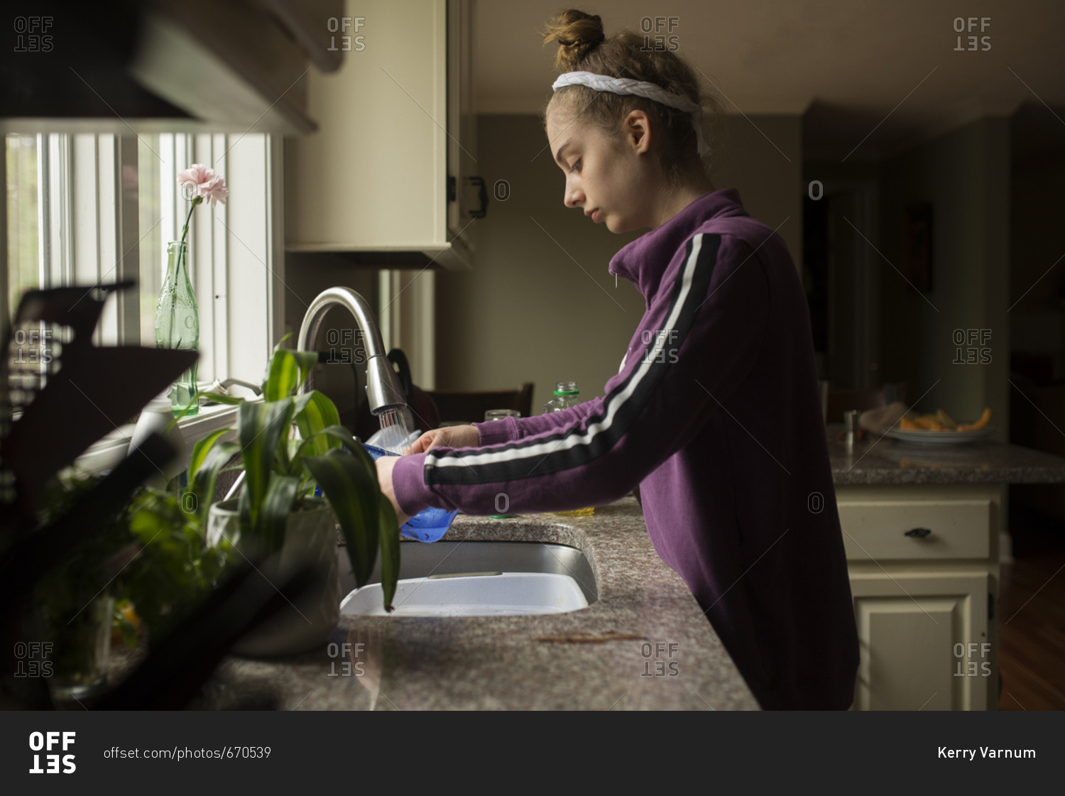 Young lady washing dishes at the sink