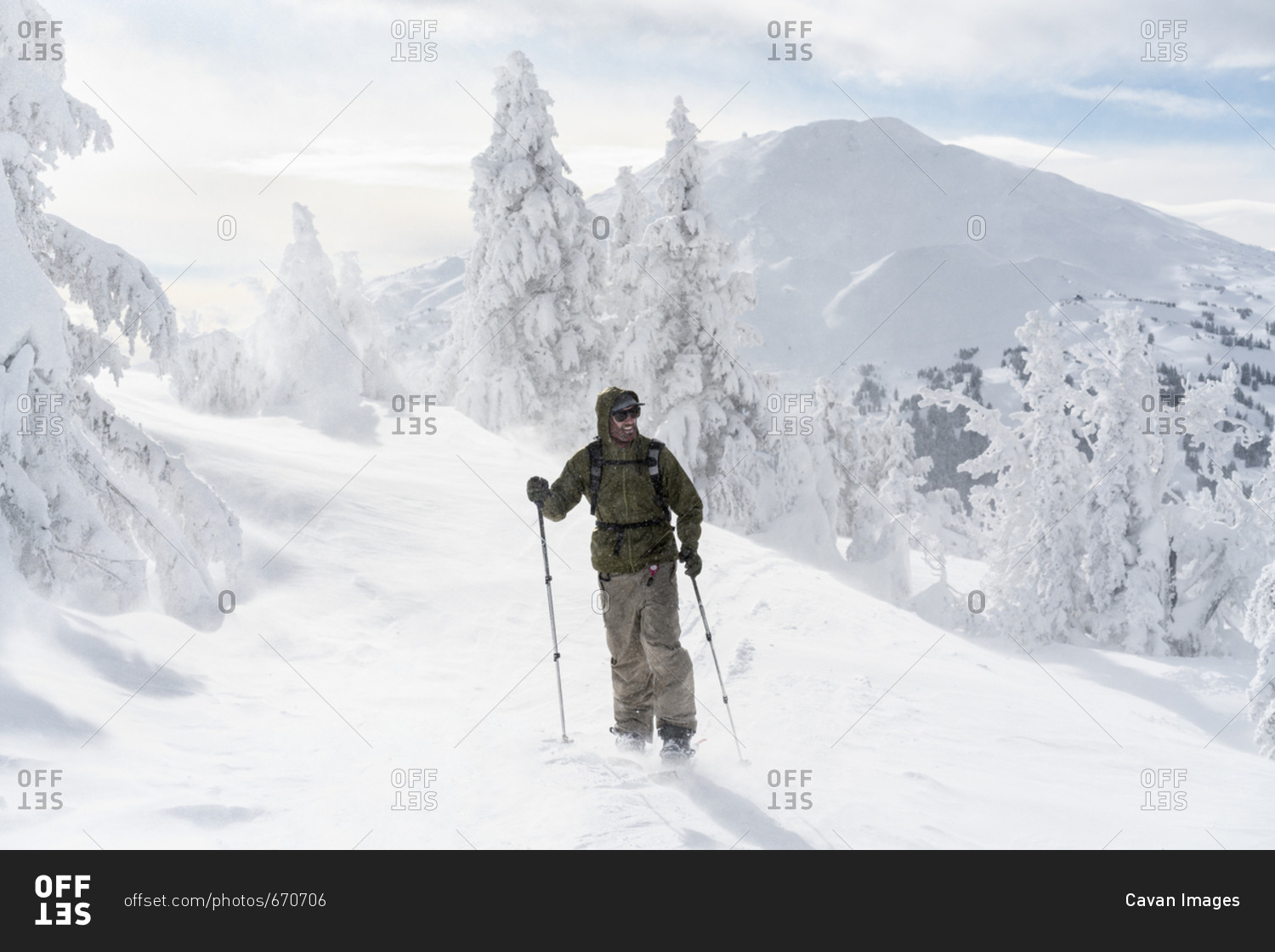 Full length of man with ski equipment standing on snowcapped mountain during foggy weather