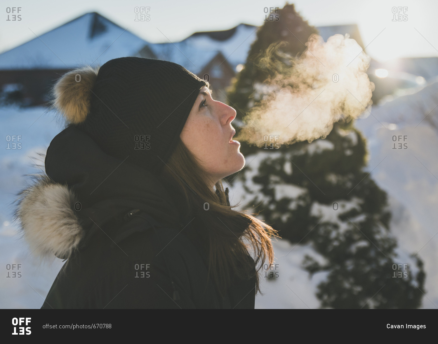 Side view of woman exhaling breath vapor during winter
