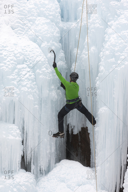 Uncompahgre National Forest, Colorado, USA - January 15, 2016: Climber ascends icy cliff face