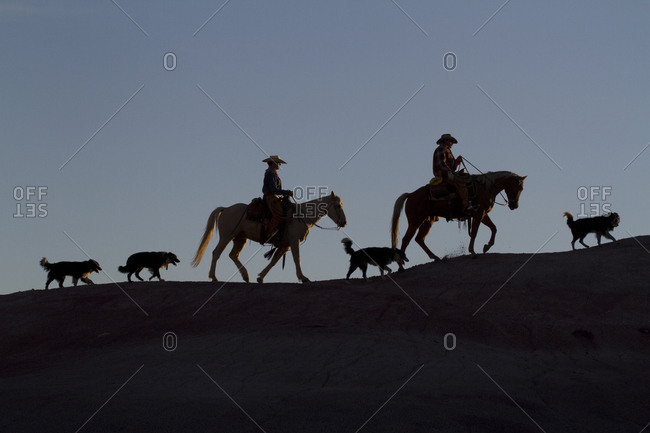 USA, Wyoming, Shell, The Hideout Ranch, Cowboys, Horses and Dogs in Early Light on Ridgeline