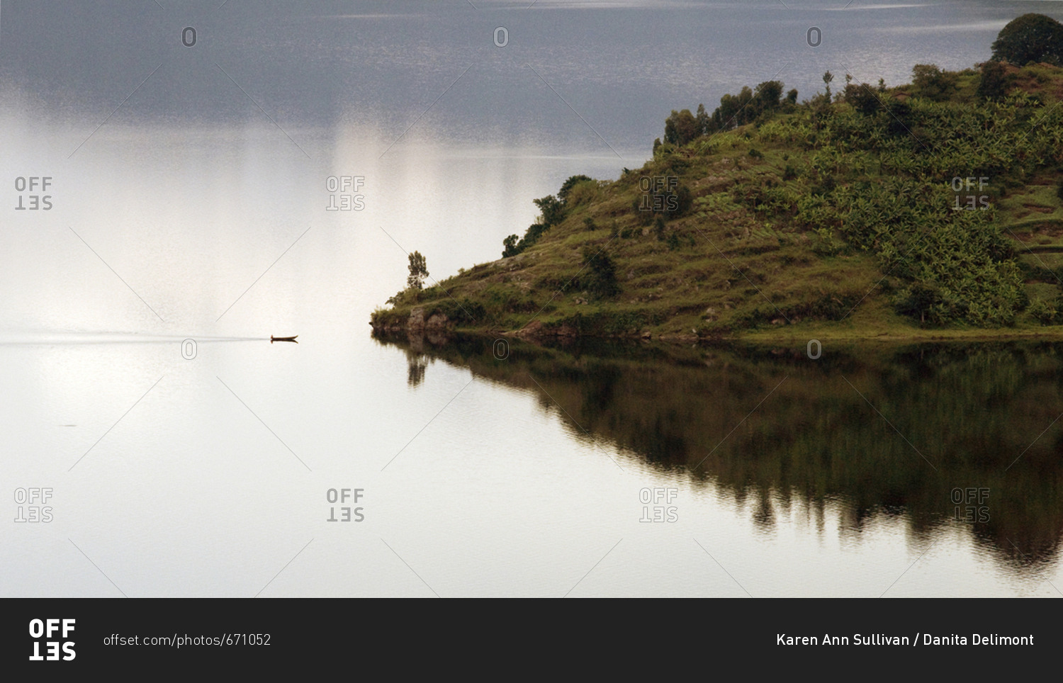 Lake Kivu, Rwanda, Africa, A small boat approaches an island in the middle of Lake Kivu