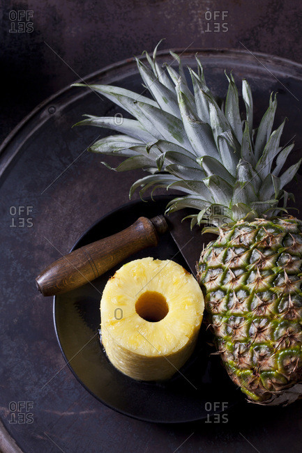 Stack of pineapple slices- whole pineapple and cleaver