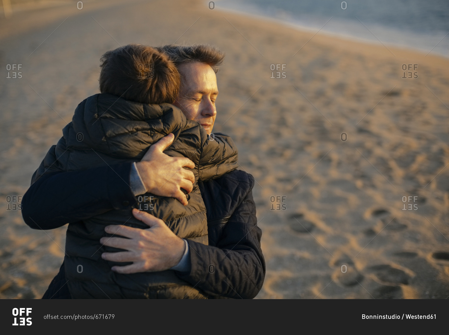 Father hugging son on the beach