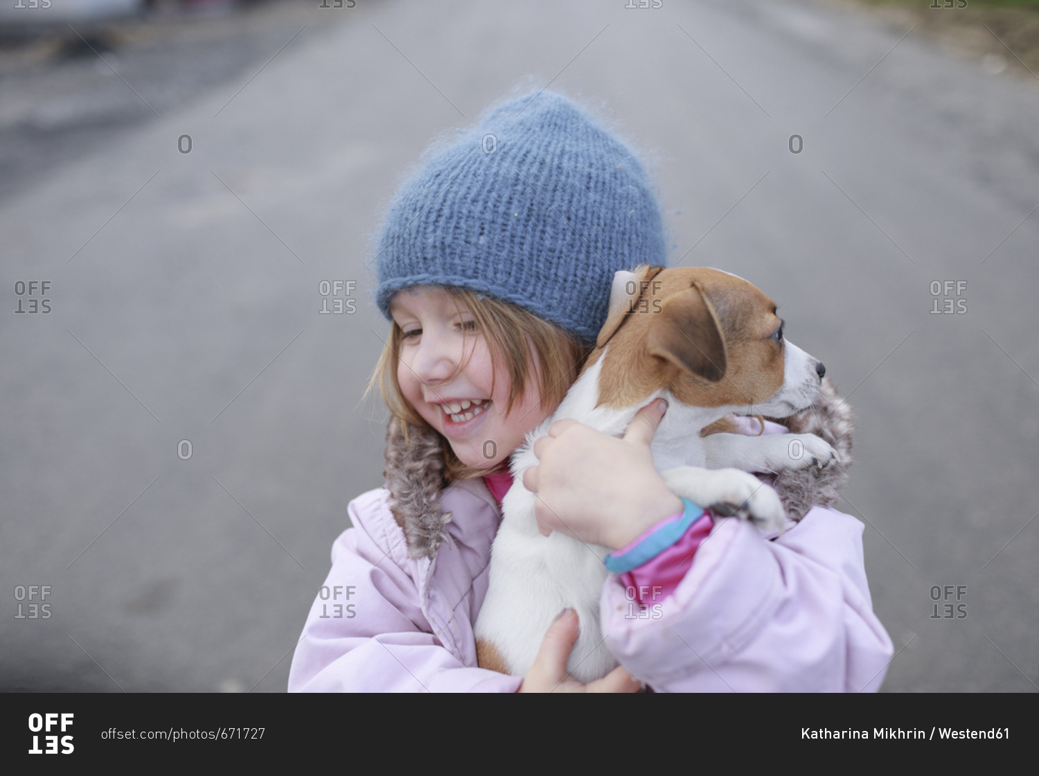 Happy little girl holding Jack Russel Terrier puppy
