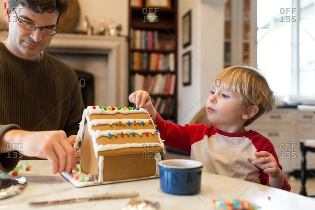 Father and son decorating gingerbread house