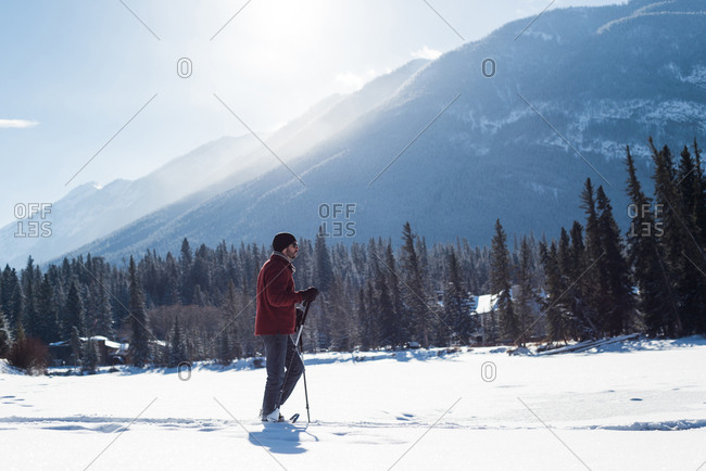 Man walking with ski poles in snowy landscape