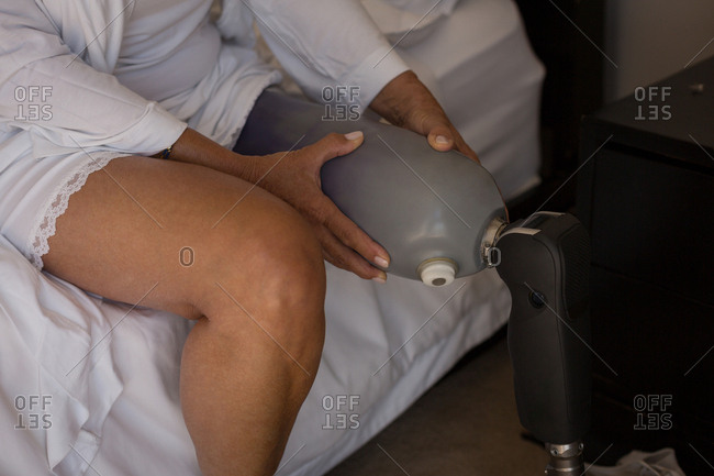 Woman with prosthetic leg in bedroom at home