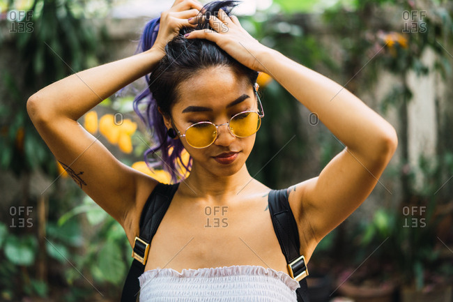 Pretty Young Asian Woman Holding Purple Hair And Posing In Park