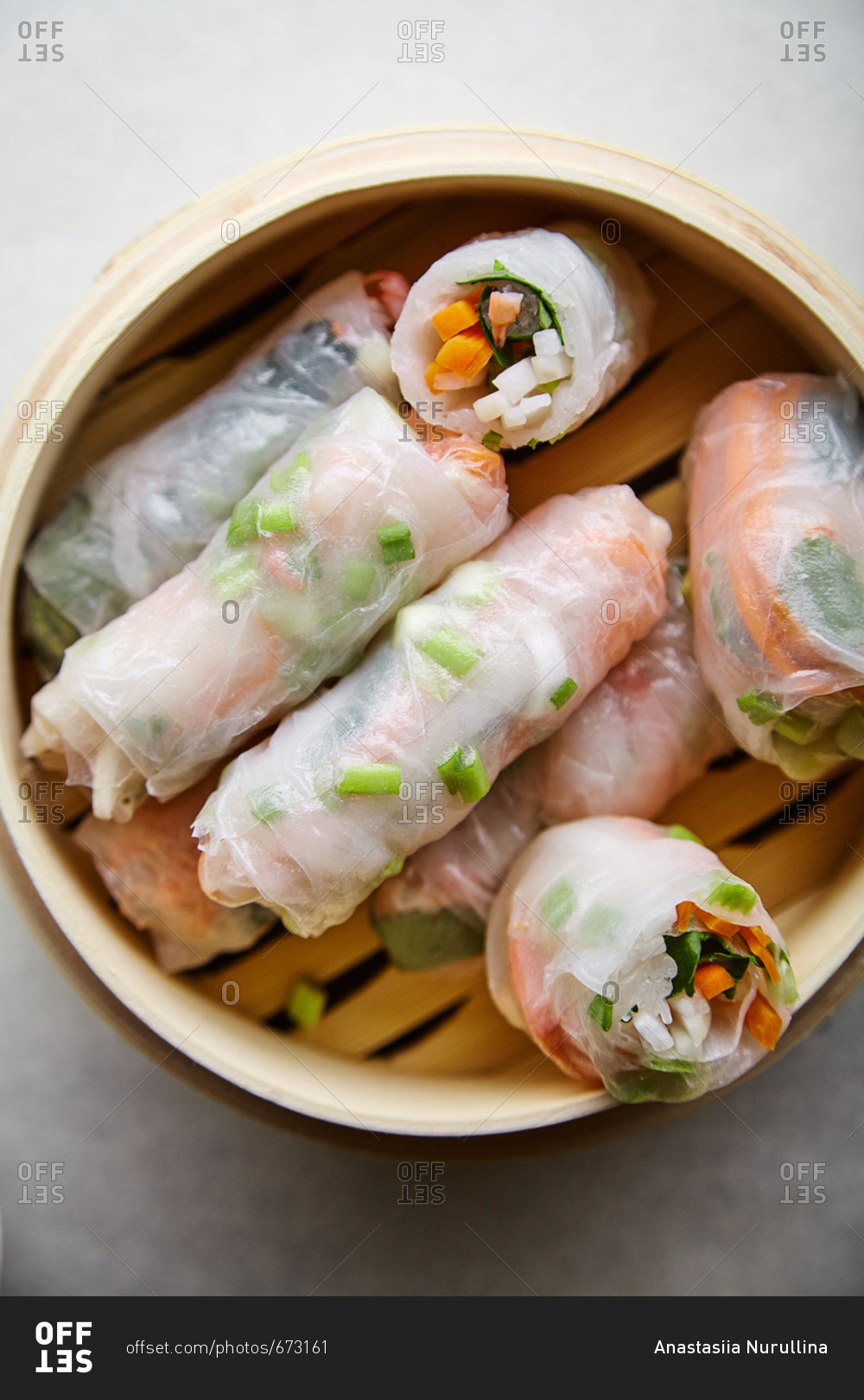 Spring rolls with marinated vegetables and shrimps on white textured background