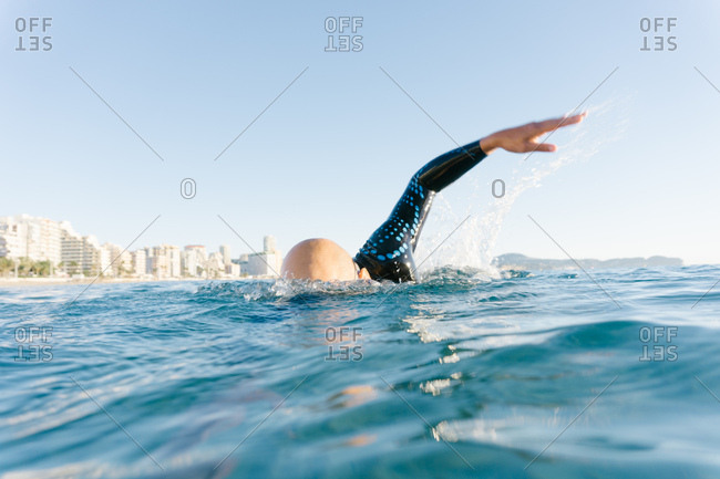 Man in wetsuit swimming in ocean