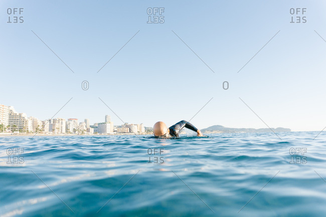 Man in wetsuit swimming in ocean