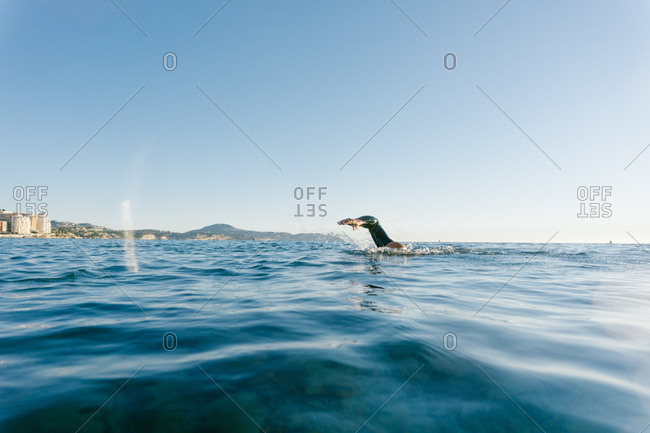 Man in wetsuit swimming in ocean