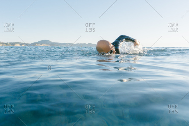 Man in wetsuit swimming in ocean