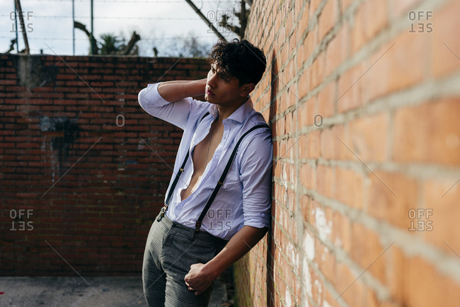Free: Portrait of a handsome young man leaning on wall with his arms  crossed Free Photo - nohat.cc