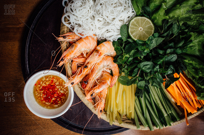 Bowl of sauce and fresh raw ingredients to make Vietnamese food