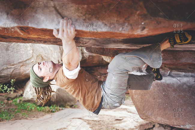 Albarracin, Spain - November 9, 2009: Rock climber bouldering through a challenging rock climbing problem