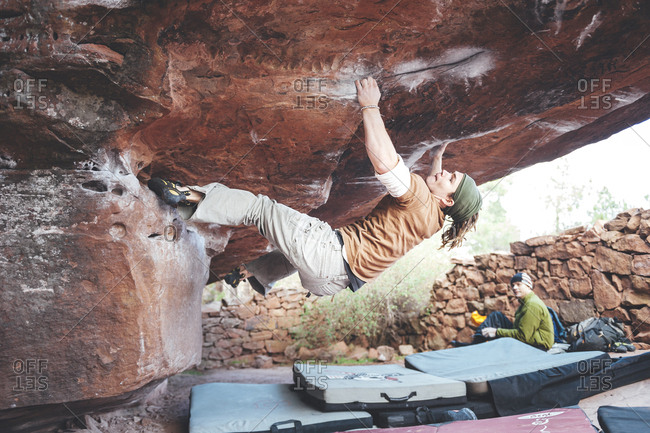 Albarracin, Spain - November 9, 2009: Rock climber climbing through a challenging boulder problem
