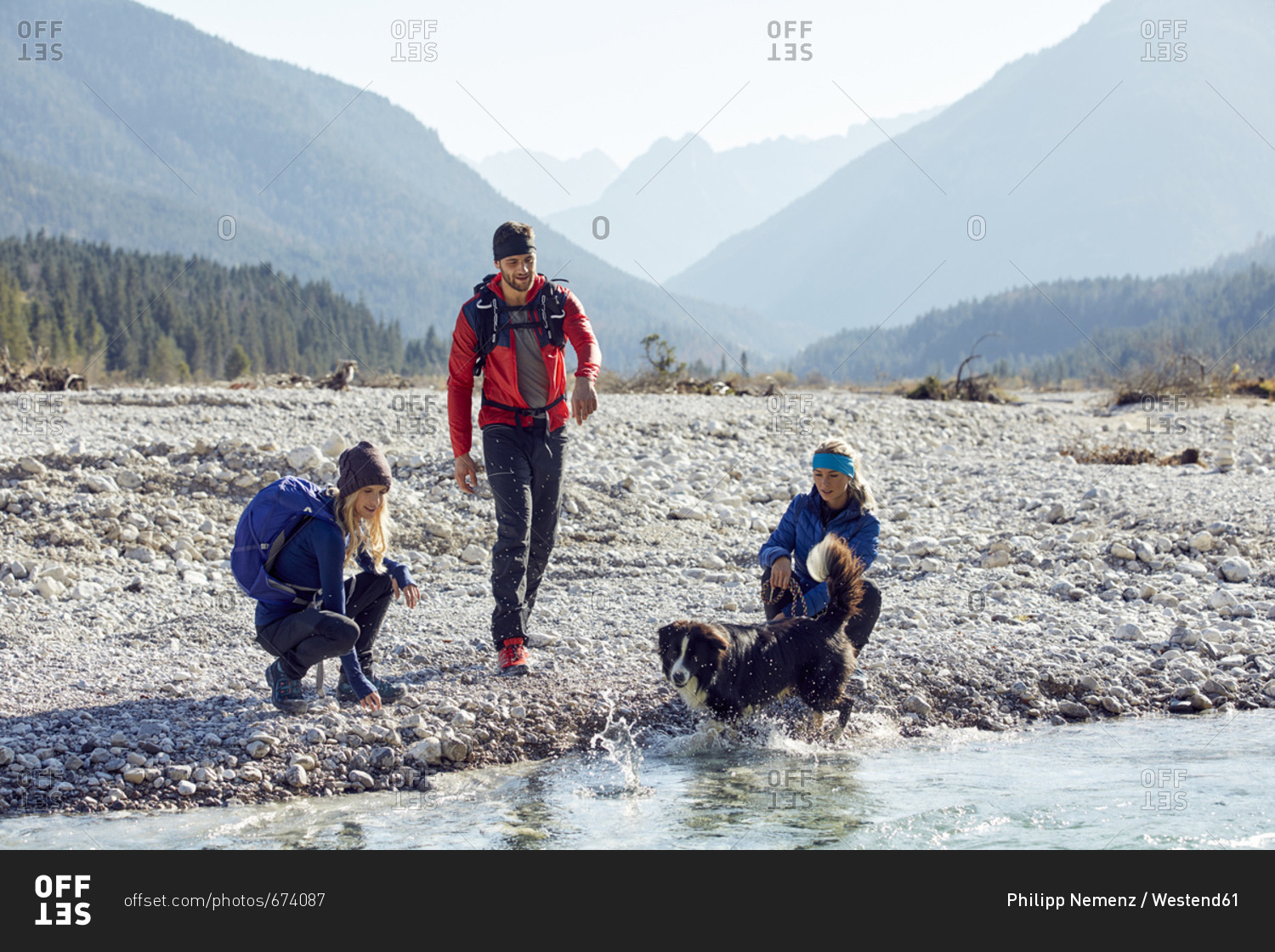 Germany- Bavaria- Karwendel- group of friends hiking with dog at the riverside