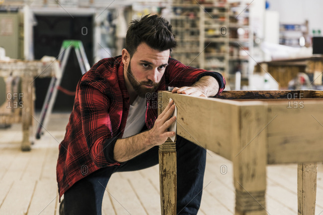 Man treating wood in workshop with sand paper