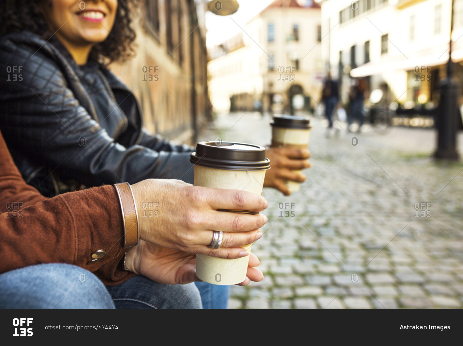 Mid section of two women holding coffee cups