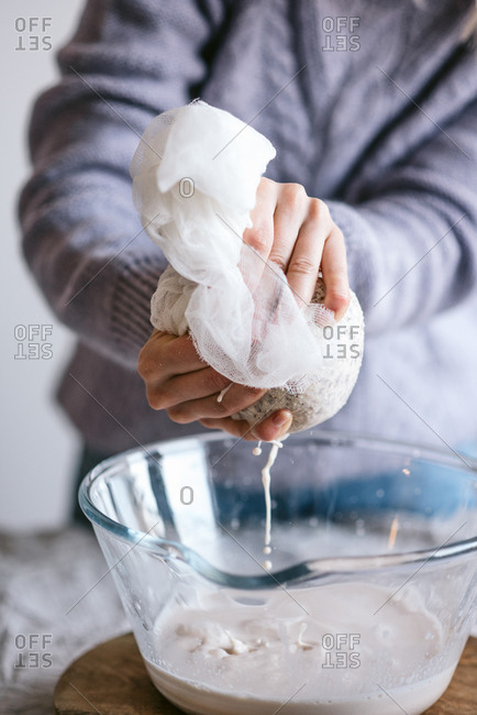 Person preparing homemade almond milk
