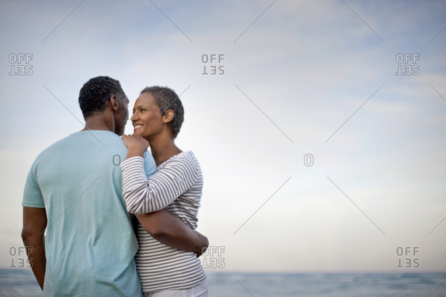 Mature couple hugging as they look out at view.