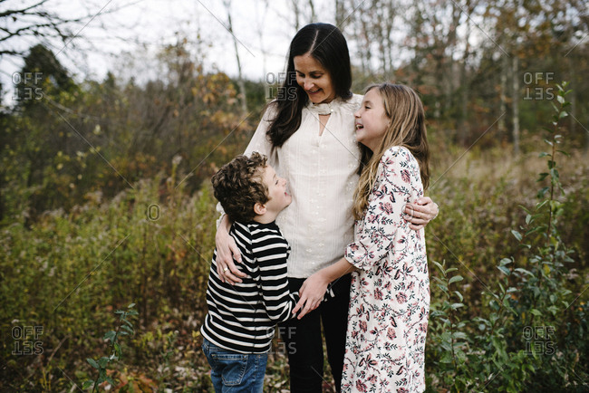 Happy siblings with mother standing at park