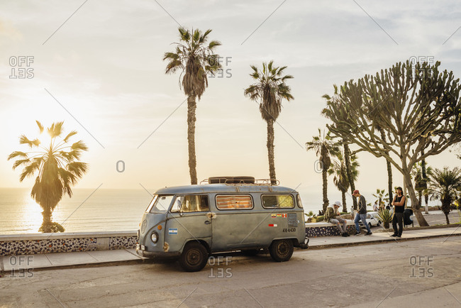 Miraflores, Lima, Peru - November 15, 2017: VW van parked along boardwalk with palms at sunset