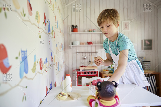 Boy serving food to doll