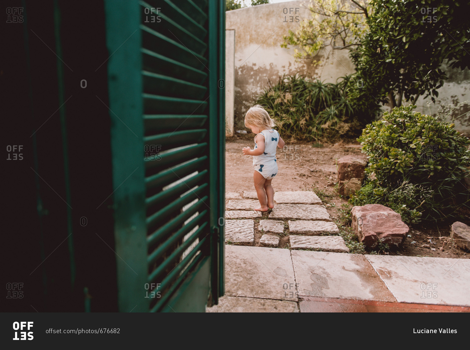 Little girl taking tentative steps on garden path