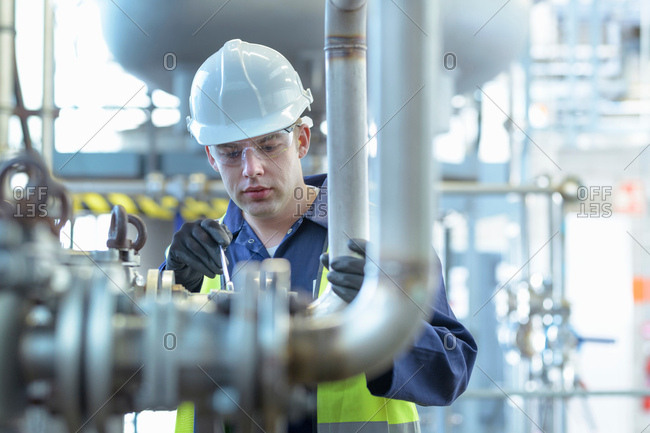 Apprentice engineer working on pipeline in industrial product facility