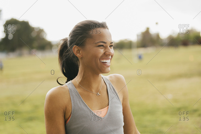 Athletic young woman looking away on grassy field at park