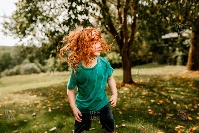 Young boy shaking wet hair in backyard