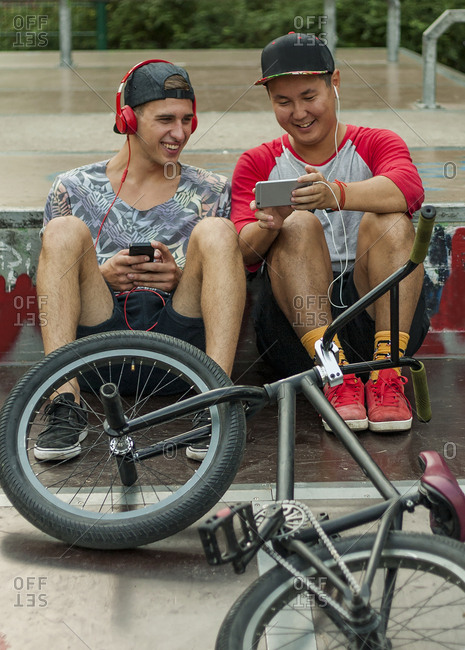 Young men with BMX bikes listening to music in BMX park, Budapest, Hungary