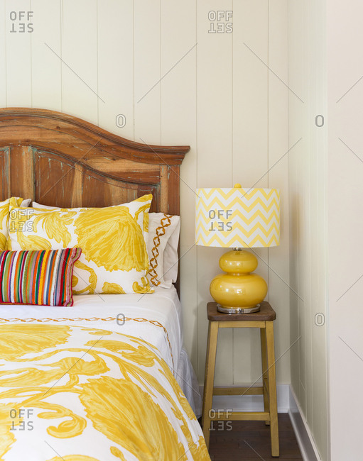 Bed in home interior with yellow decor