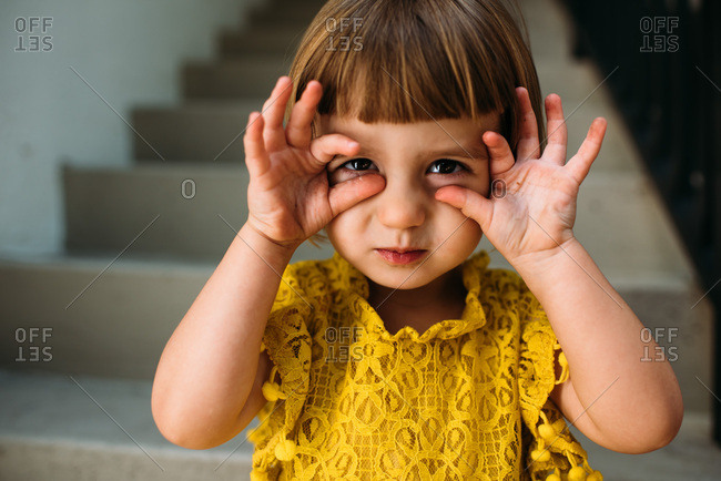 Little Girl On Steps Making A Funny Face Stock Photo Offset