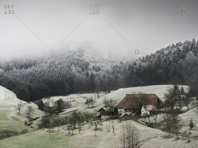 Farmhouse Hofbauernhof, snowy meadows and forest in little village in the Middle Black Forest, Elzach-Yach, Baden-Wurttemberg, Germany.