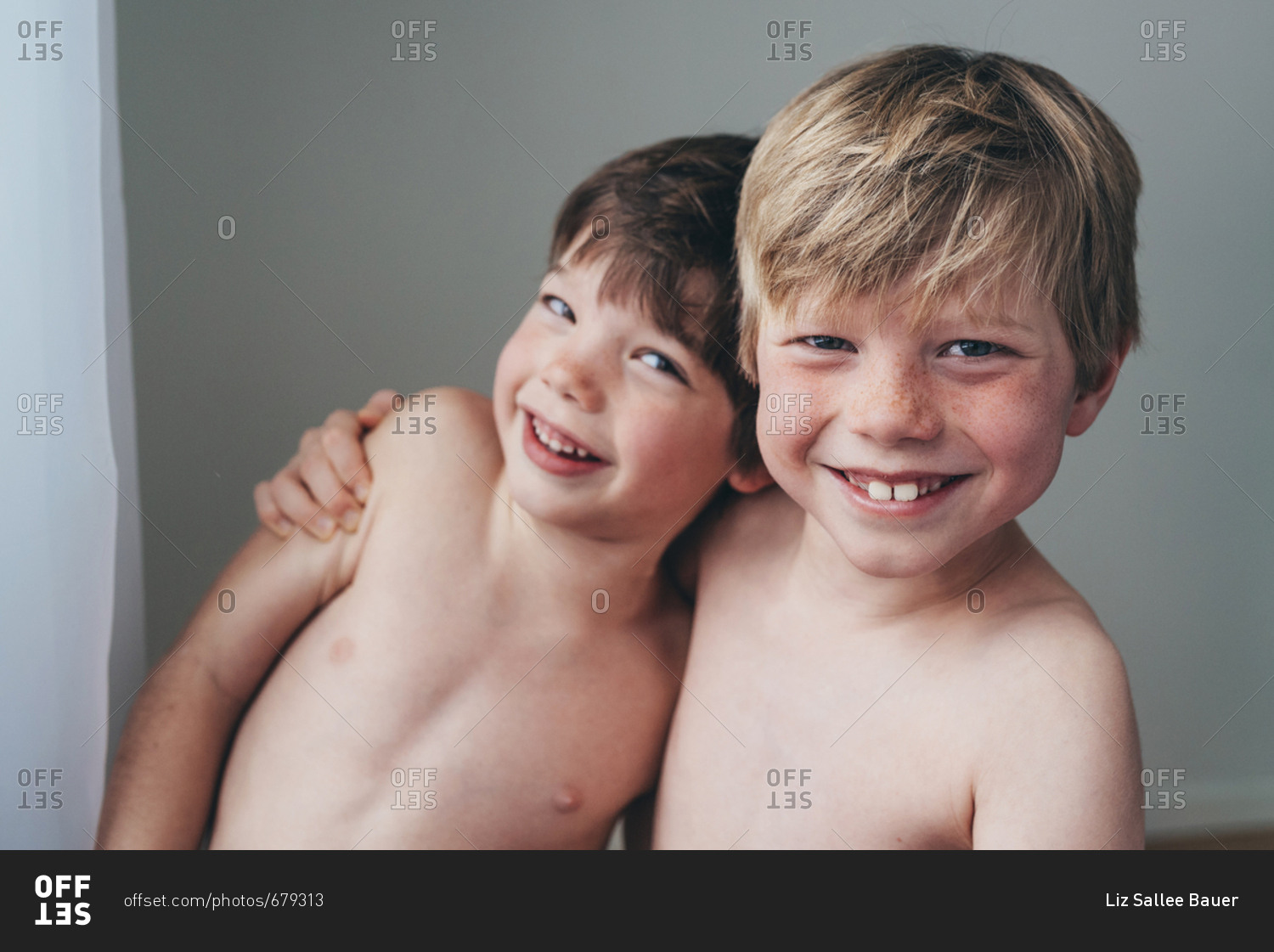 Two happy young boys with arms around each other