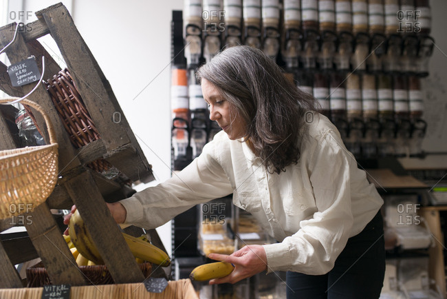 Woman Stocking Bananas In Small Local Grocery Store Stock Images Page Everypixel