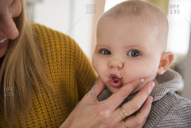 Mother squeezing baby's (12-17 months) face