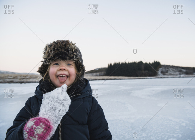 Portrait of playful girl sticking out tongue while holding ice