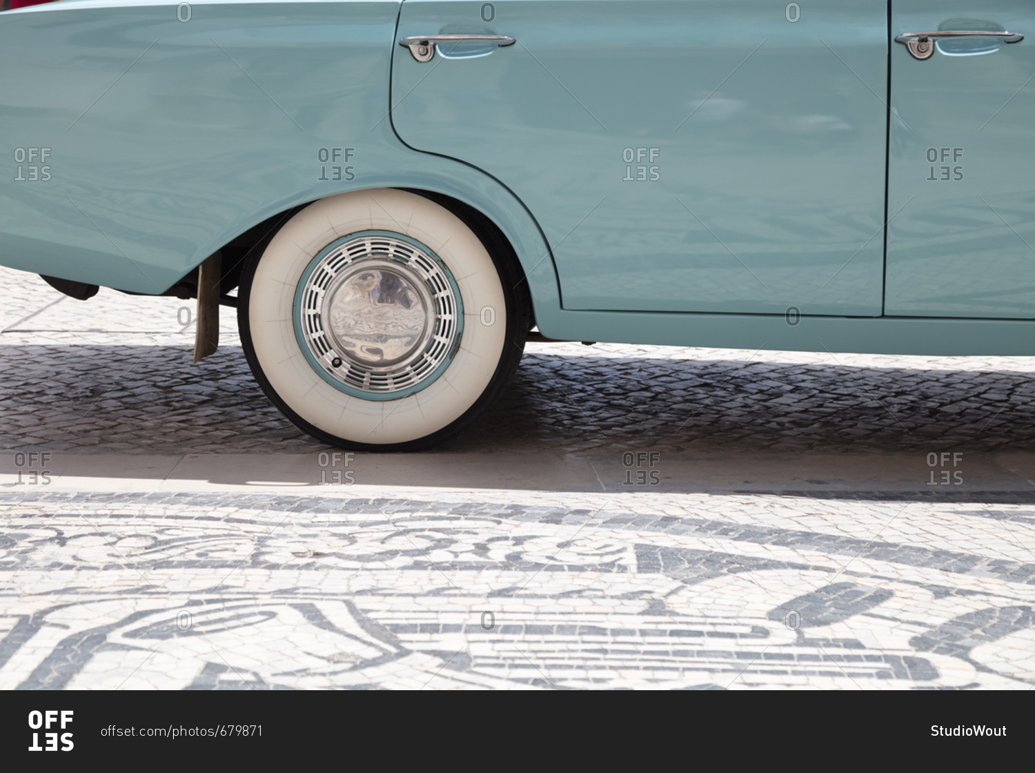 Detail of rear quarter panel, whitewall tires and chrome hubcap of vintage car